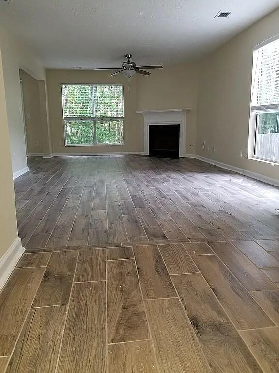 5030 N Bridges Dr, Alpharetta, GA 30022 - unfurnished living room featuring wood finished floors, a ceiling fan, and a fireplace