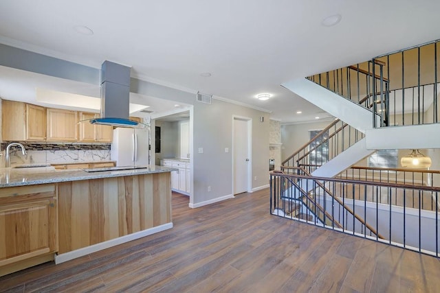 kitchen featuring white refrigerator, light stone counters, light brown cabinets, island range hood, and crown molding