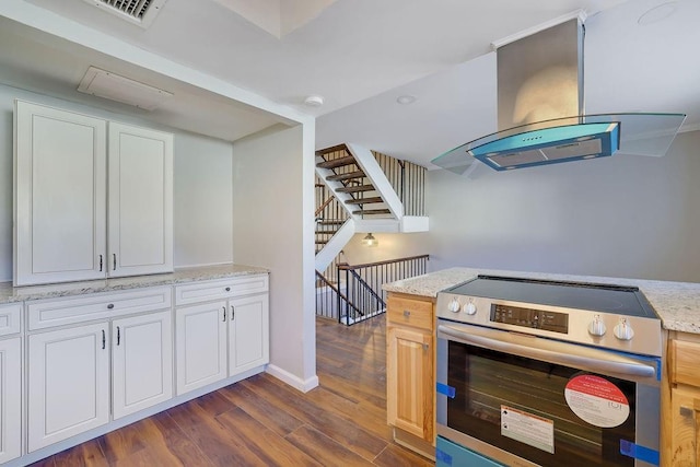 kitchen with white cabinets, island range hood, stainless steel electric range oven, and dark wood-type flooring