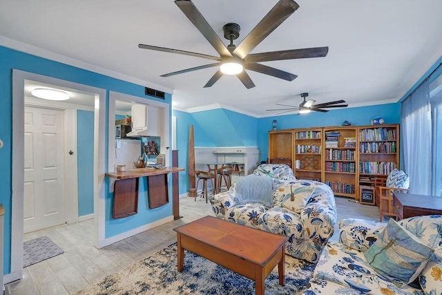 living room featuring light wood-type flooring, ceiling fan, and crown molding