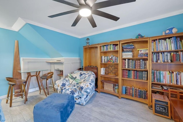 sitting room featuring ceiling fan, light wood-type flooring, and ornamental molding