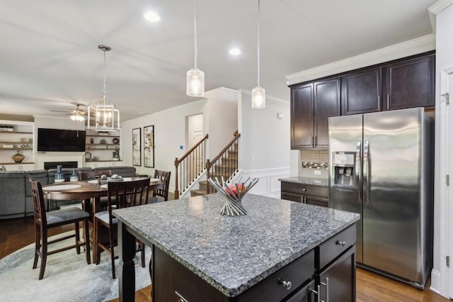 6977 Demeter Dr, Atlanta, GA 30349 - kitchen featuring stainless steel fridge with ice dispenser, ceiling fan, crown molding, dark stone counters, and wood finished floors