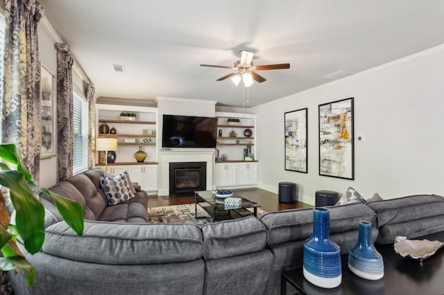 6977 Demeter Dr, Atlanta, GA 30349 - living area featuring wood finished floors, a ceiling fan, a fireplace with flush hearth, crown molding, and baseboards