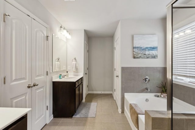 6977 Demeter Dr, Atlanta, GA 30349 - bathroom featuring tile patterned floors, vanity, a garden tub, and baseboards