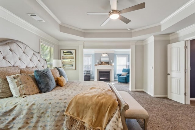 6977 Demeter Dr, Atlanta, GA 30349 - carpeted bedroom featuring a tray ceiling, multiple windows, ornamental molding, and a ceiling fan