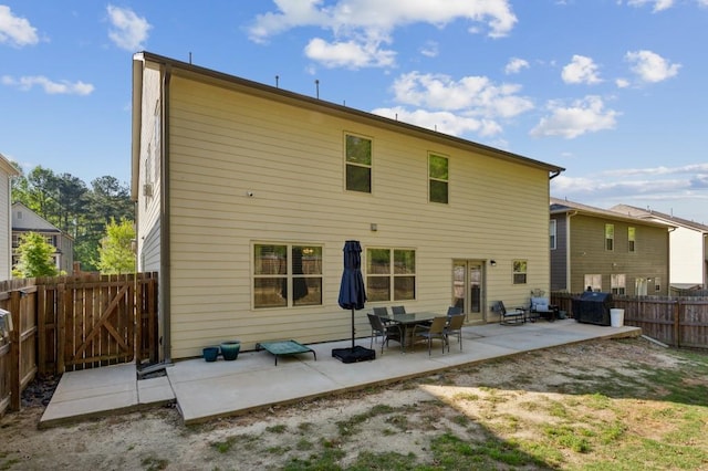 6977 Demeter Dr, Atlanta, GA 30349 - rear view of house with a patio area, a fenced backyard, and a gate