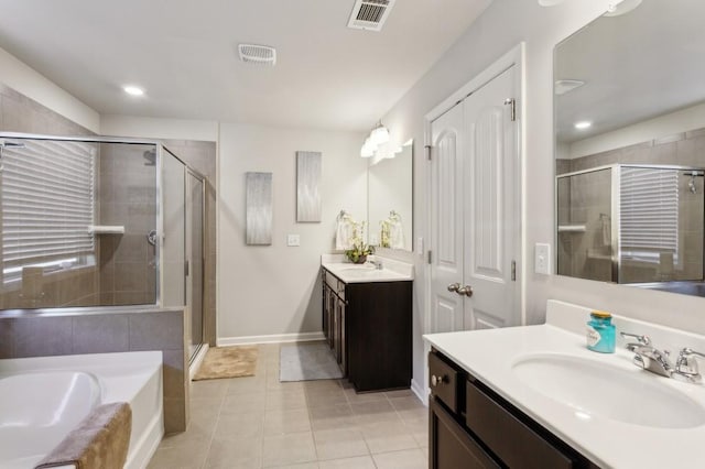 6977 Demeter Dr, Atlanta, GA 30349 - full bathroom featuring a shower stall, tile patterned floors, baseboards, two vanities, and a garden tub