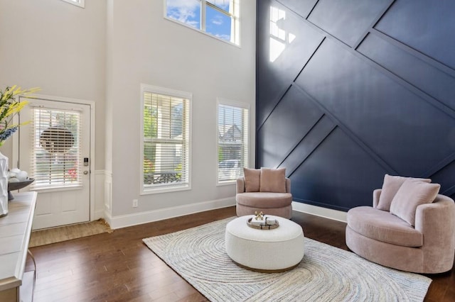 6977 Demeter Dr, Atlanta, GA 30349 - living area featuring wood finished floors, healthy amount of natural light, a wainscoted wall, and a high ceiling