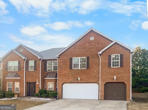 view of front of property with brick siding, a garage, and driveway