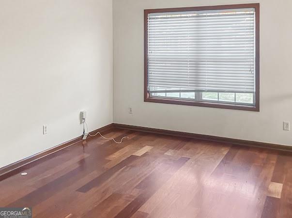 empty room with wood finished floors and baseboards