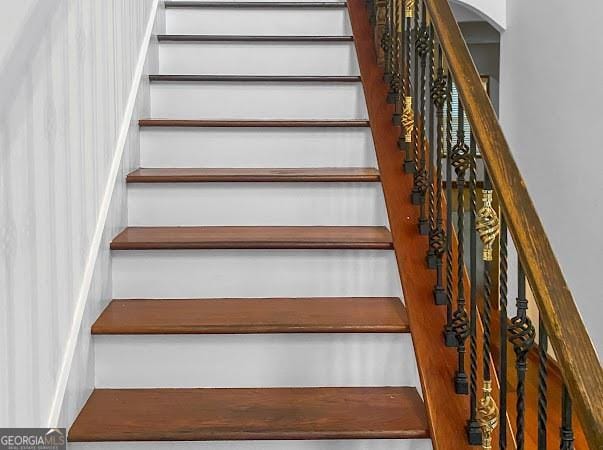 staircase featuring arched walkways