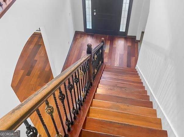 stairs featuring wood finished floors