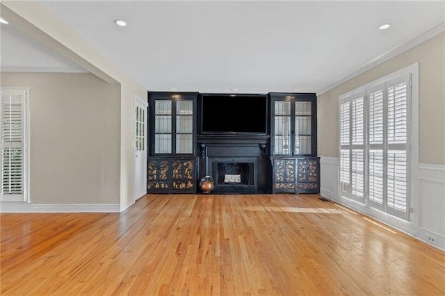 3231 Connemara Trce, Lawrenceville, GA 30044 - unfurnished living room with wood finished floors, a fireplace, crown molding, a wainscoted wall, and recessed lighting