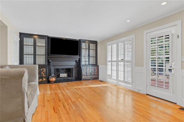 3231 Connemara Trce, Lawrenceville, GA 30044 - living room with a fireplace, wood finished floors, crown molding, a wainscoted wall, and recessed lighting