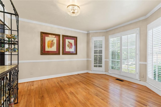3231 Connemara Trce, Lawrenceville, GA 30044 - spare room with wood finished floors, a chandelier, baseboards, and crown molding