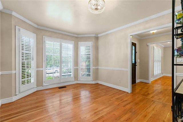 3231 Connemara Trce, Lawrenceville, GA 30044 - empty room featuring light wood finished floors, a chandelier, baseboards, and ornamental molding