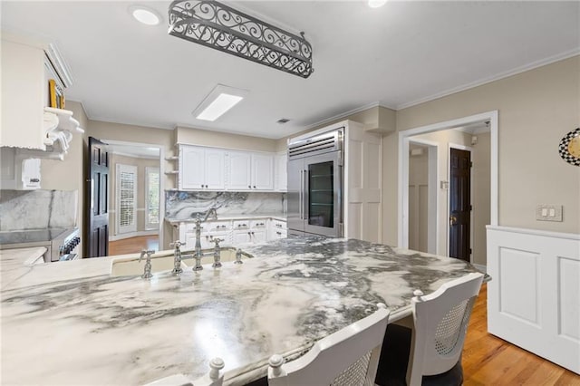 3231 Connemara Trce, Lawrenceville, GA 30044 - kitchen featuring stainless steel built in fridge, open shelves, a peninsula, tasteful backsplash, and light wood finished floors