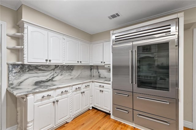 3231 Connemara Trce, Lawrenceville, GA 30044 - kitchen with stainless steel built in refrigerator, light wood finished floors, white cabinetry, and crown molding