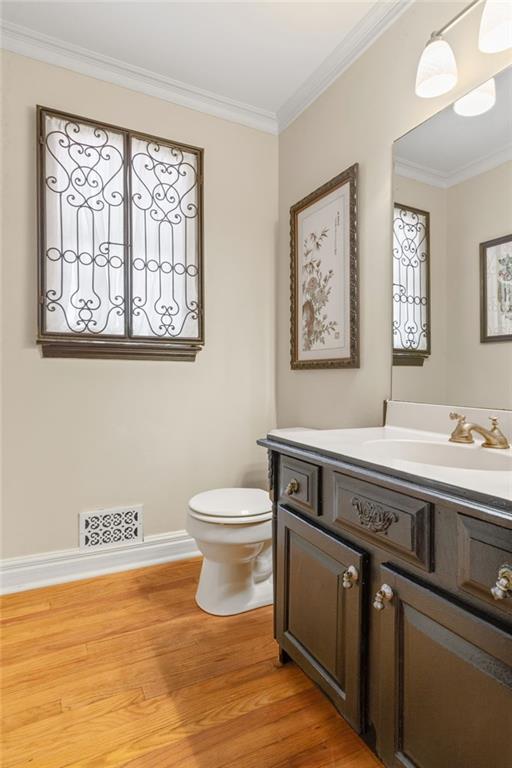 3231 Connemara Trce, Lawrenceville, GA 30044 - half bath with vanity, crown molding, toilet, and wood finished floors