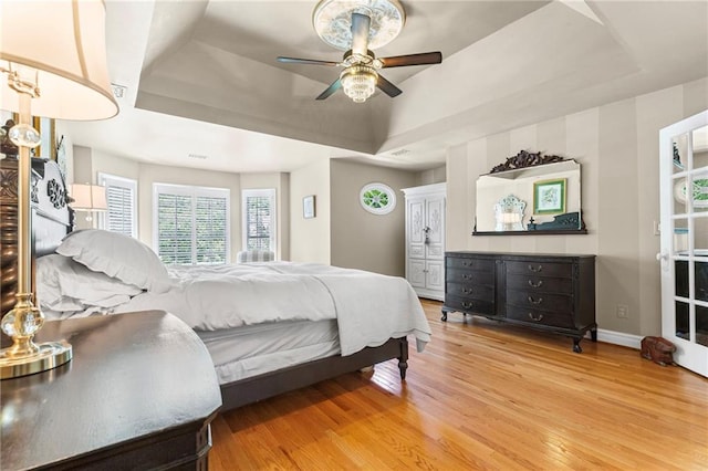 3231 Connemara Trce, Lawrenceville, GA 30044 - bedroom featuring a tray ceiling, light wood-style flooring, baseboards, and a ceiling fan