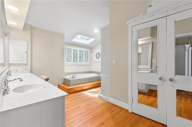 3231 Connemara Trce, Lawrenceville, GA 30044 - full bath with a skylight, a garden tub, double vanity, wood finished floors, and lofted ceiling
