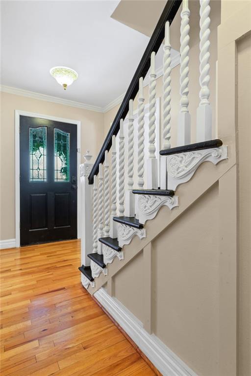 3231 Connemara Trce, Lawrenceville, GA 30044 - foyer entrance with crown molding, stairway, and light wood-type flooring