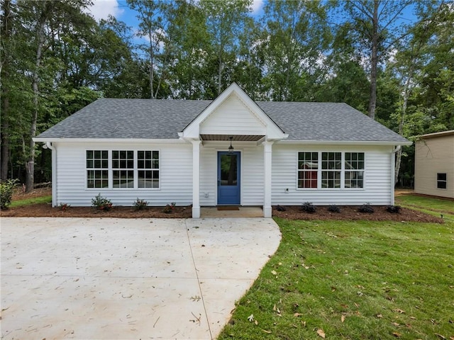 ranch-style home featuring a front lawn and a shingled roof