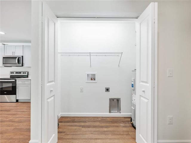 laundry area with washer hookup, hookup for an electric dryer, light wood-style flooring, and baseboards