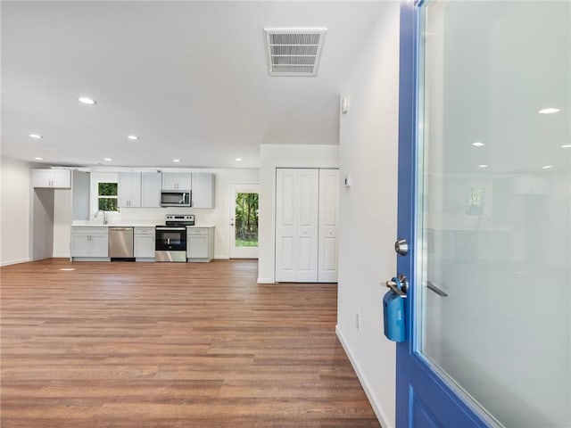 interior space with light wood finished floors, baseboards, visible vents, and recessed lighting