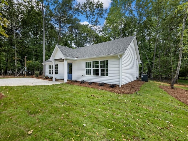 view of front of property featuring a shingled roof, a patio area, a front lawn, and central air condition unit