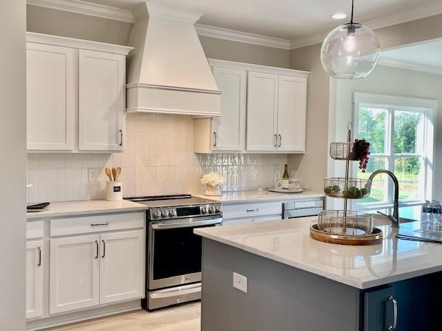 kitchen with premium range hood, stainless steel electric range oven, white cabinets, and hanging light fixtures