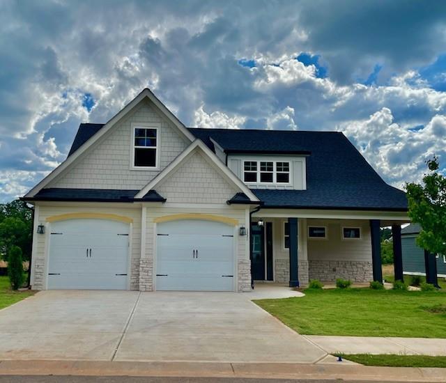 craftsman inspired home with a front yard and a garage