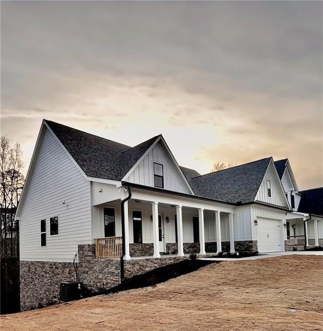 modern farmhouse featuring a garage, central AC, and a porch