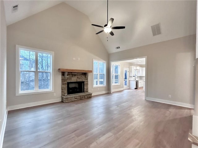 unfurnished living room with high vaulted ceiling, hardwood / wood-style floors, a fireplace, and ceiling fan