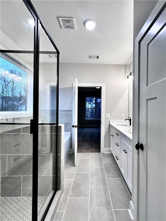 bathroom featuring vanity, tile patterned flooring, and a shower with door