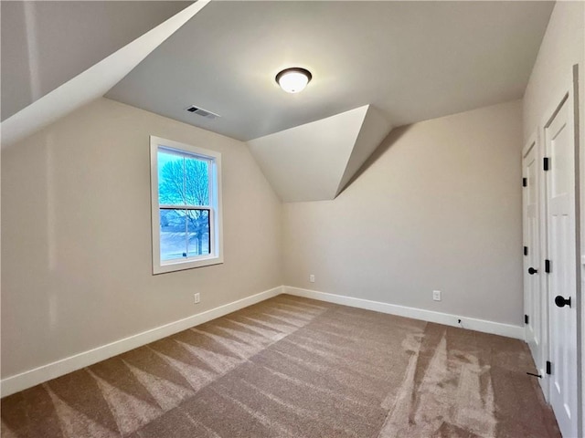 bonus room with lofted ceiling and carpet flooring