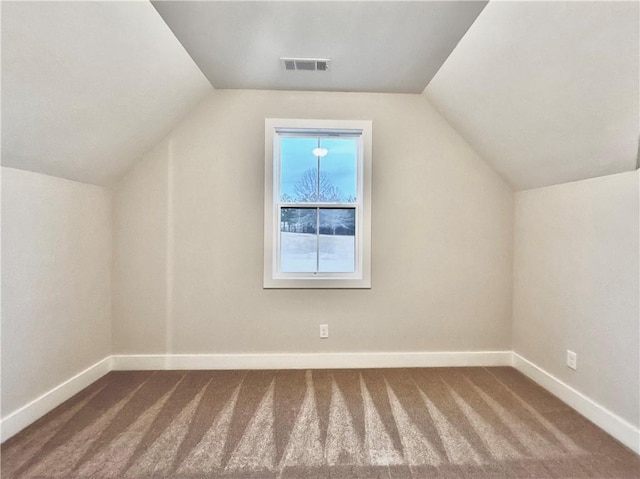 additional living space featuring lofted ceiling and carpet