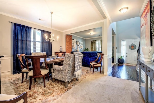 345 Piedmont Cir, Covington, GA 30016 - dining room featuring a chandelier, ornamental molding, a wainscoted wall, a decorative wall, and wood finished floors