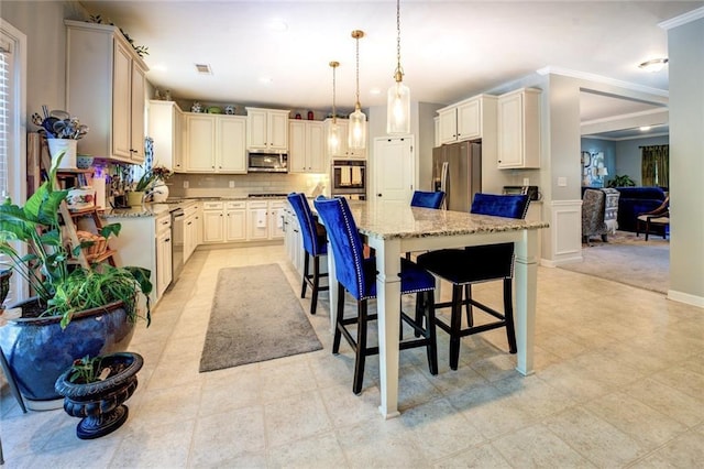 345 Piedmont Cir, Covington, GA 30016 - kitchen with stainless steel appliances, a center island, light stone countertops, crown molding, and a kitchen breakfast bar