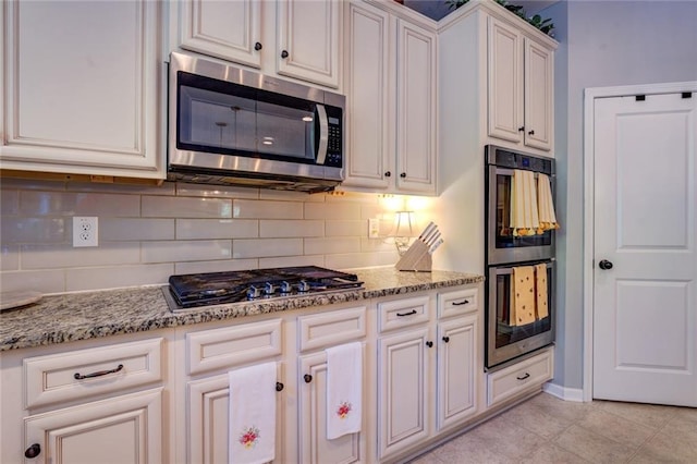 345 Piedmont Cir, Covington, GA 30016 - kitchen featuring stainless steel appliances, tasteful backsplash, light stone counters, and white cabinets