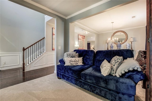 345 Piedmont Cir, Covington, GA 30016 - carpeted living room featuring a chandelier, stairs, ornamental molding, a decorative wall, and wood finished floors