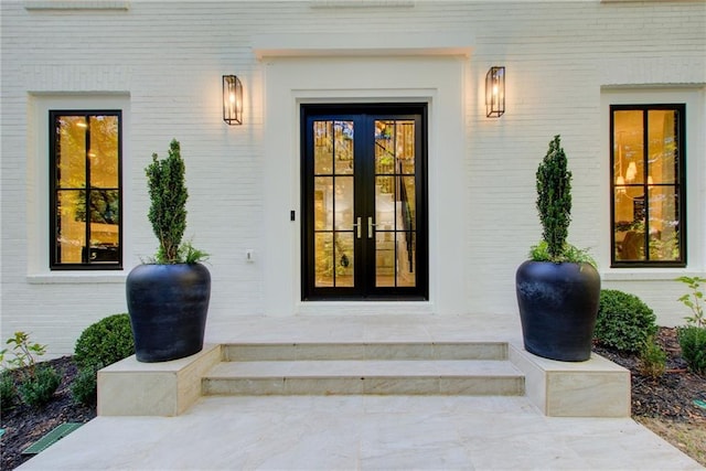 entrance to property featuring brick siding and french doors