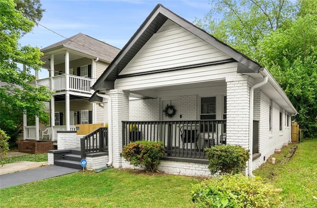 view of front of property featuring covered porch and a front lawn