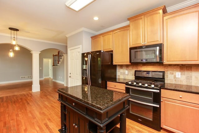 kitchen featuring ornate columns, a kitchen island, tasteful backsplash, dark stone countertops, and black appliances