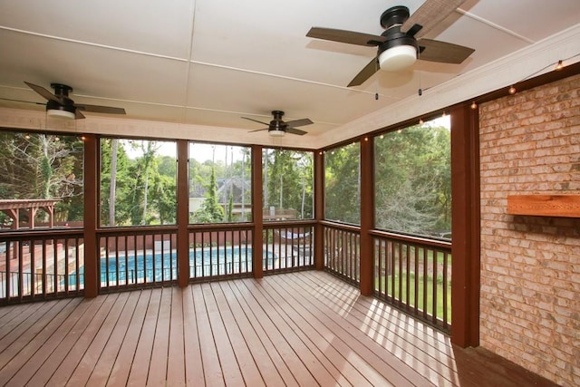 unfurnished sunroom with ceiling fan