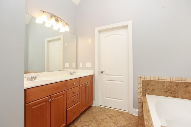 bathroom featuring tiled tub, vanity, and tile patterned flooring