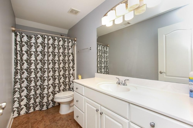 bathroom featuring vanity, tile patterned floors, and toilet