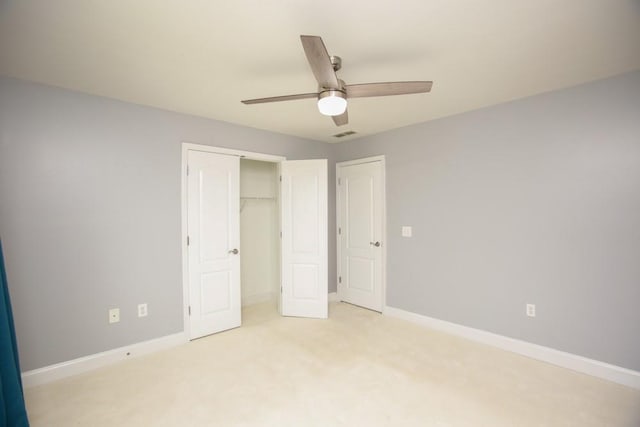 unfurnished bedroom featuring light carpet, a closet, and ceiling fan