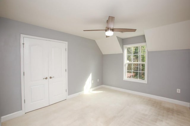 additional living space with lofted ceiling, light carpet, and ceiling fan