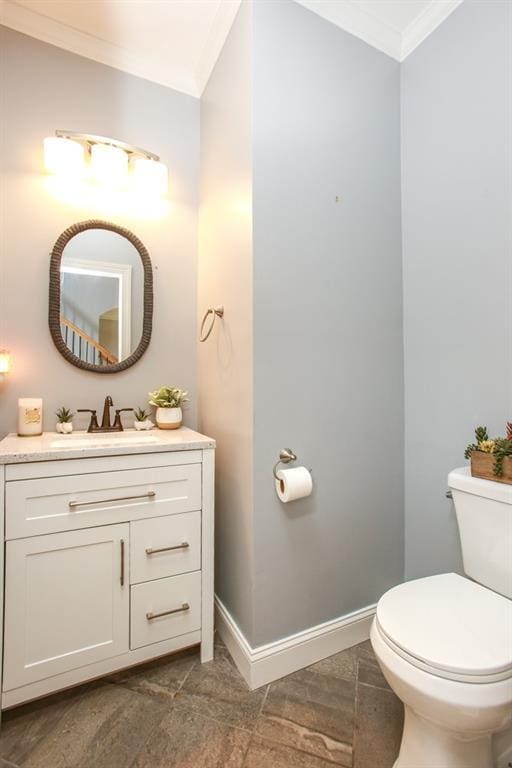 bathroom featuring ornamental molding, toilet, and vanity